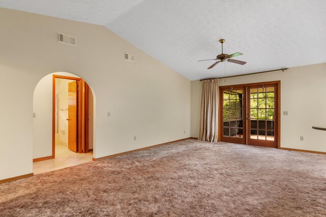 carpeted spare room featuring ceiling fan, high vaulted ceiling, and a textured ceiling