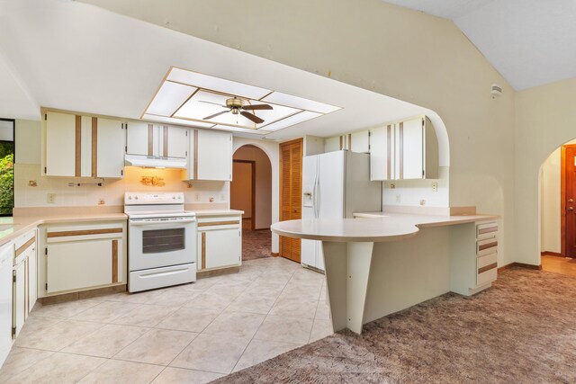 kitchen featuring ceiling fan, light colored carpet, kitchen peninsula, white appliances, and vaulted ceiling