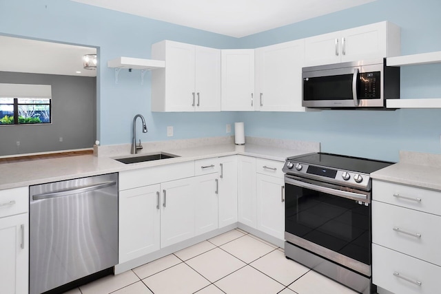 kitchen featuring sink, appliances with stainless steel finishes, white cabinets, and light tile patterned flooring