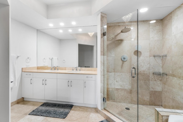 bathroom with double vanity, a stall shower, a sink, and recessed lighting