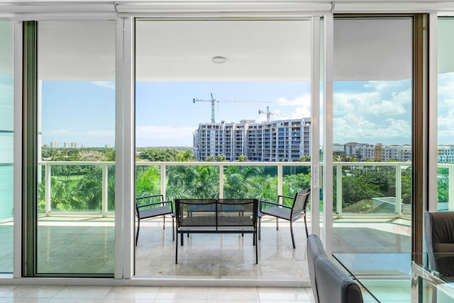 doorway featuring a wall of windows, a view of city, and tile patterned floors