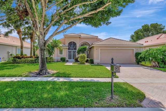 mediterranean / spanish-style house with a front yard and a garage