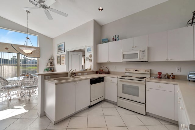 kitchen with sink, light tile patterned floors, kitchen peninsula, white appliances, and white cabinets