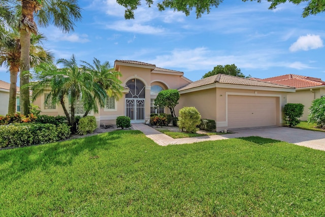 mediterranean / spanish-style home featuring a front yard and a garage