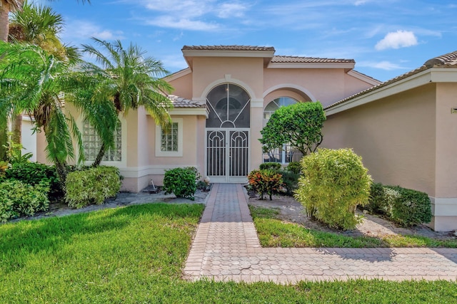 property entrance with a lawn