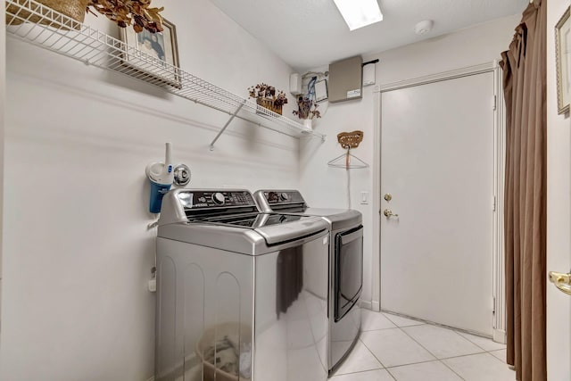 laundry room with independent washer and dryer and light tile patterned floors