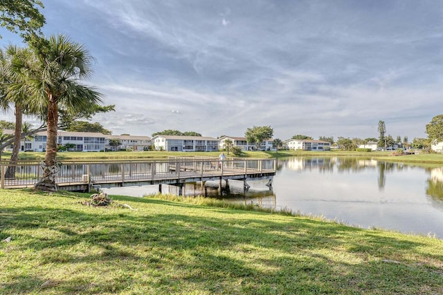 view of dock featuring a lawn and a water view