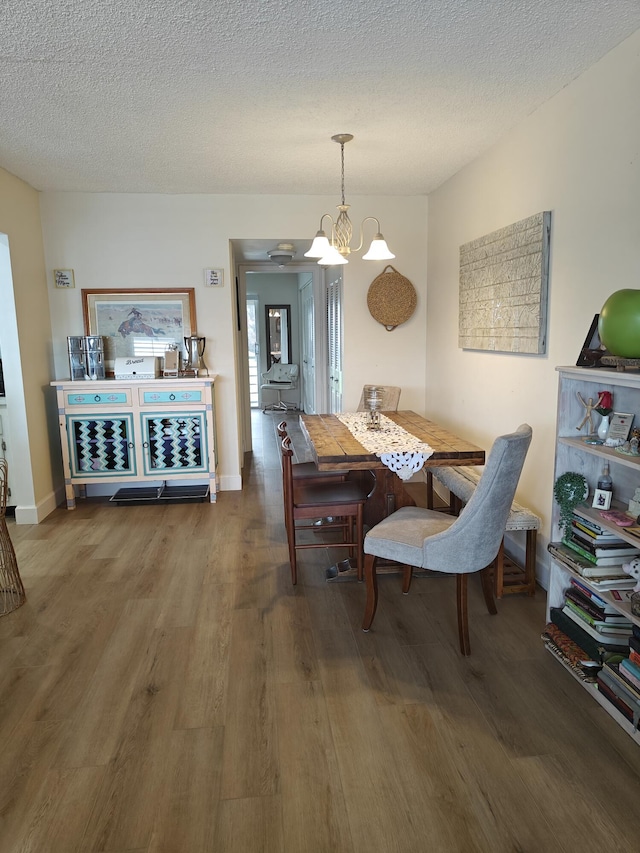 dining room featuring a notable chandelier, a textured ceiling, and wood finished floors