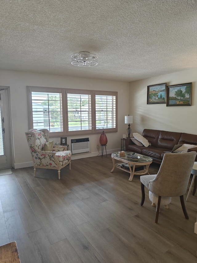 living room with a textured ceiling, baseboards, wood finished floors, and a healthy amount of sunlight