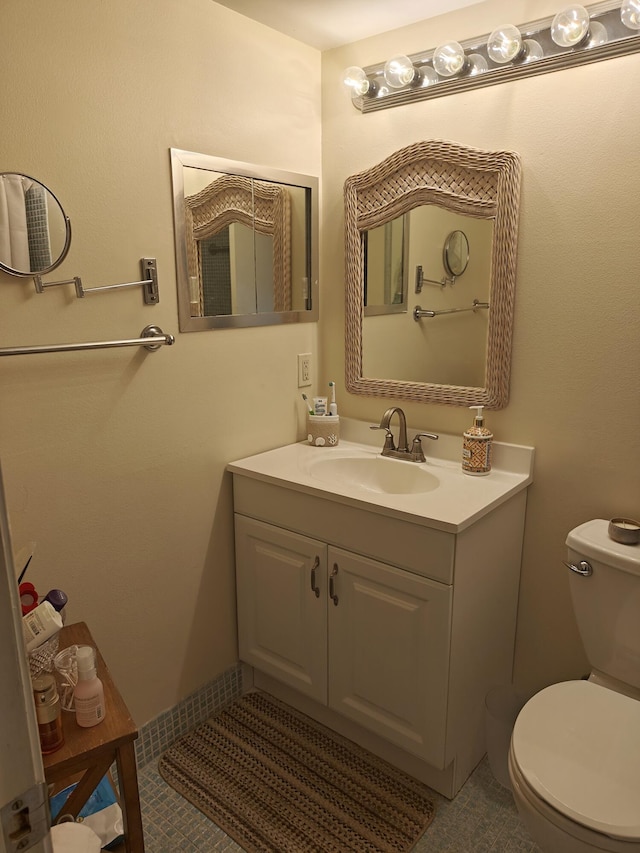 half bathroom with tile patterned flooring, vanity, and toilet