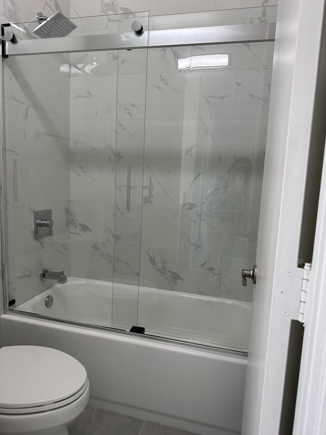 bathroom with bath / shower combo with glass door and toilet