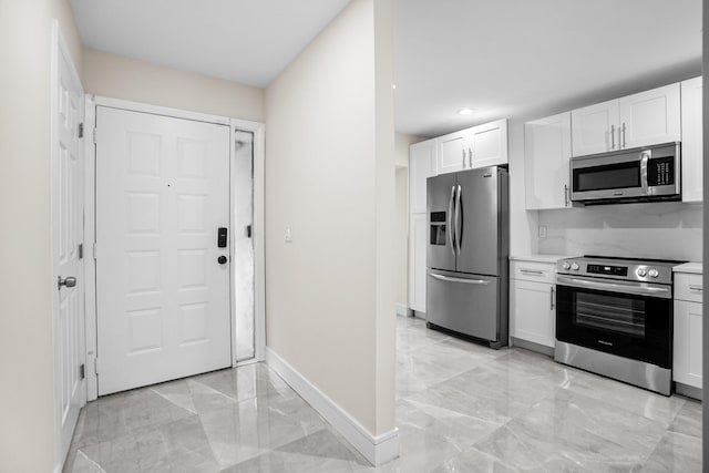 4820 NW 22nd St Unit 4134, Coconut Creek, FL 33063 - kitchen with appliances with stainless steel finishes, light marble finish floors, baseboards, white cabinetry, and recessed lighting