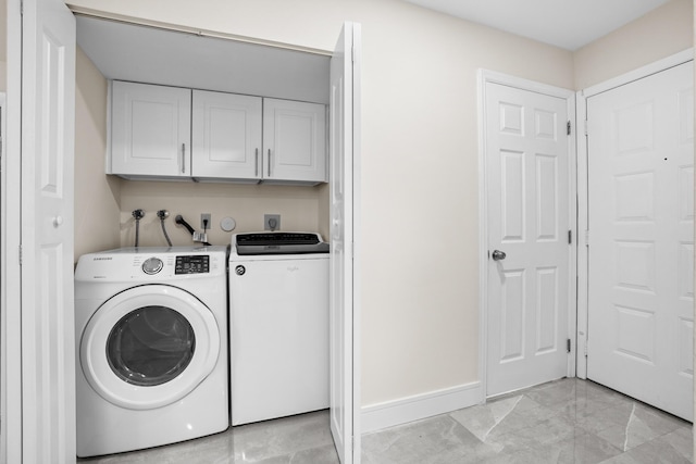 4820 NW 22nd St Unit 4134, Coconut Creek, FL 33063 - washroom featuring light marble finish flooring, washer and clothes dryer, baseboards, and cabinet space