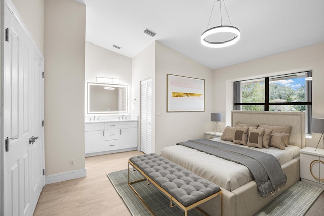 4820 NW 22nd St Unit 4134, Coconut Creek, FL 33063 - bedroom featuring lofted ceiling, light wood-style flooring, ensuite bath, baseboards, and a sink