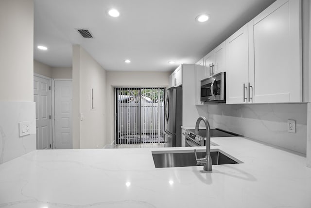 4820 NW 22nd St Unit 4134, Coconut Creek, FL 33063 - kitchen featuring appliances with stainless steel finishes, light stone countertops, recessed lighting, a sink, and white cabinetry