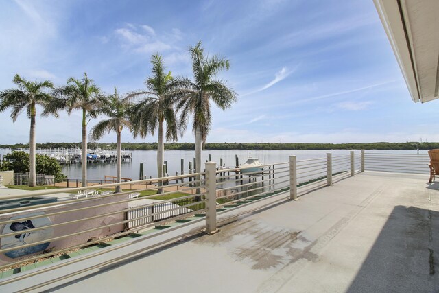 view of patio with a boat dock and a water view