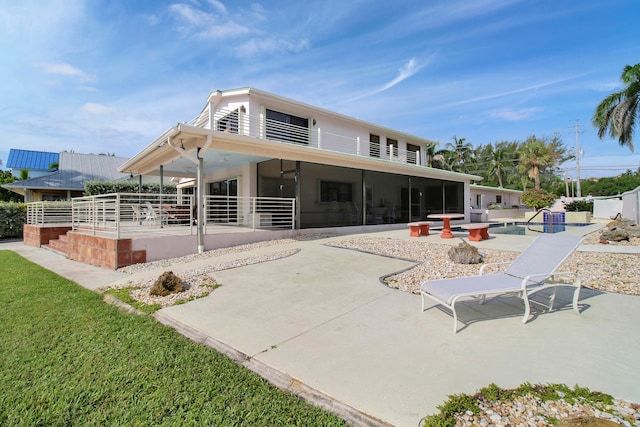 rear view of property featuring a sunroom and a patio area