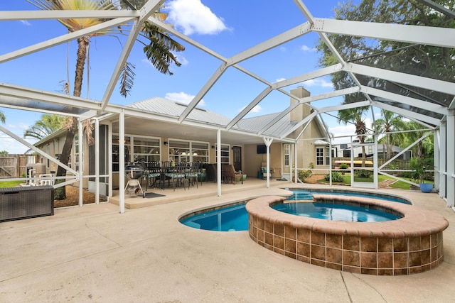 view of pool with a lanai, a patio area, and an in ground hot tub