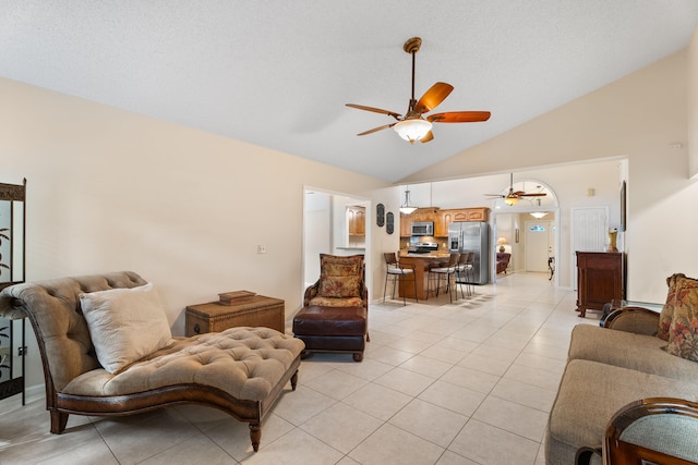 living room with ceiling fan, high vaulted ceiling, and light tile patterned floors