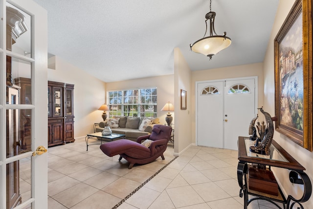 tiled entrance foyer with vaulted ceiling, french doors, and a textured ceiling