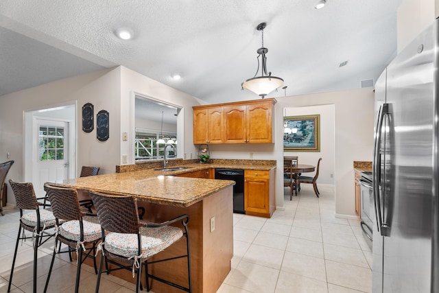 kitchen featuring sink, stainless steel fridge, a kitchen breakfast bar, black dishwasher, and kitchen peninsula