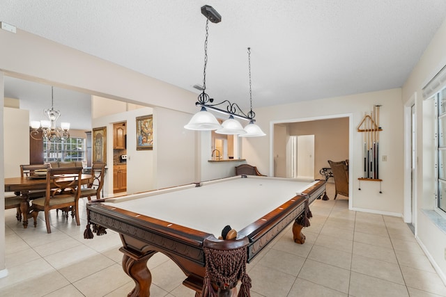 recreation room with pool table, a notable chandelier, a textured ceiling, and light tile patterned floors