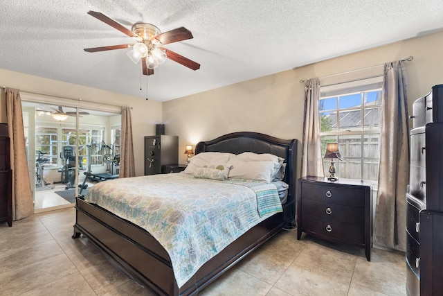 tiled bedroom with ceiling fan and a textured ceiling