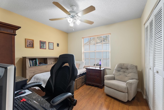 office with ceiling fan, light hardwood / wood-style floors, and a textured ceiling