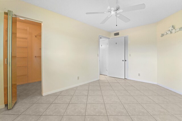 tiled spare room with ceiling fan