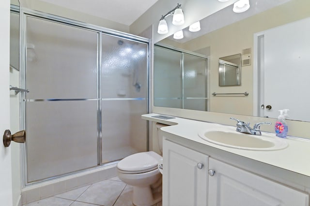 bathroom with an enclosed shower, vanity, tile patterned floors, and toilet