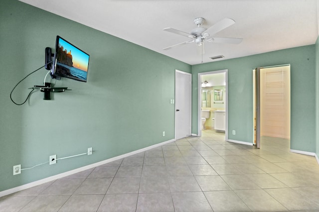 tiled empty room featuring ceiling fan