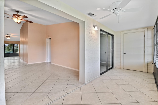 unfurnished room with light tile patterned floors, vaulted ceiling, and ceiling fan