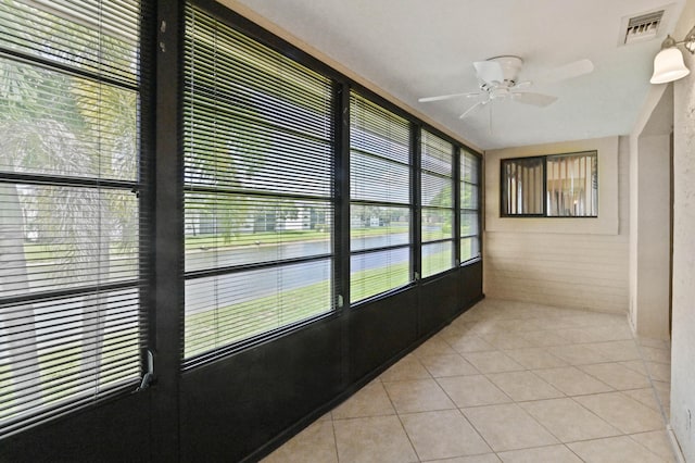 unfurnished sunroom featuring ceiling fan