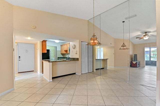 kitchen featuring high vaulted ceiling, decorative backsplash, light tile patterned floors, ceiling fan, and black fridge