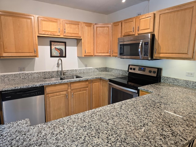 kitchen featuring sink, stainless steel appliances, and stone countertops