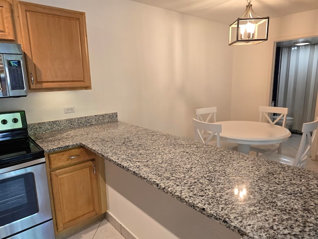 kitchen featuring light tile patterned flooring, stainless steel appliances, light stone counters, and hanging light fixtures