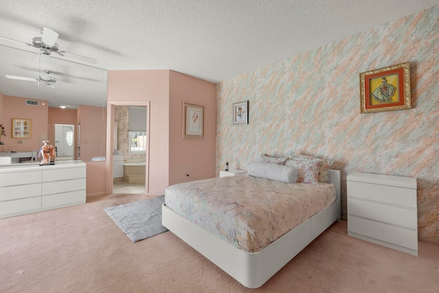 carpeted bedroom featuring ceiling fan, connected bathroom, and a textured ceiling