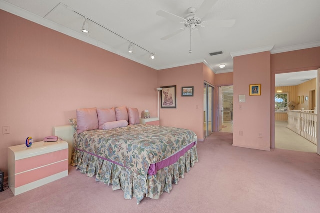 carpeted bedroom with track lighting, ensuite bathroom, ceiling fan, and ornamental molding