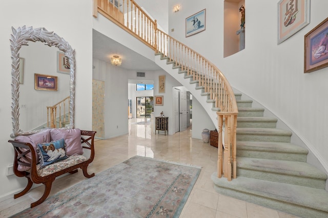 stairway with a high ceiling and tile patterned flooring