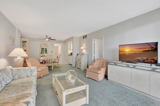 carpeted living room with ceiling fan