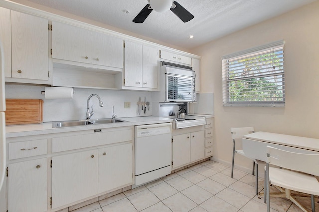 kitchen with light tile patterned floors, white cabinets, dishwasher, ceiling fan, and sink