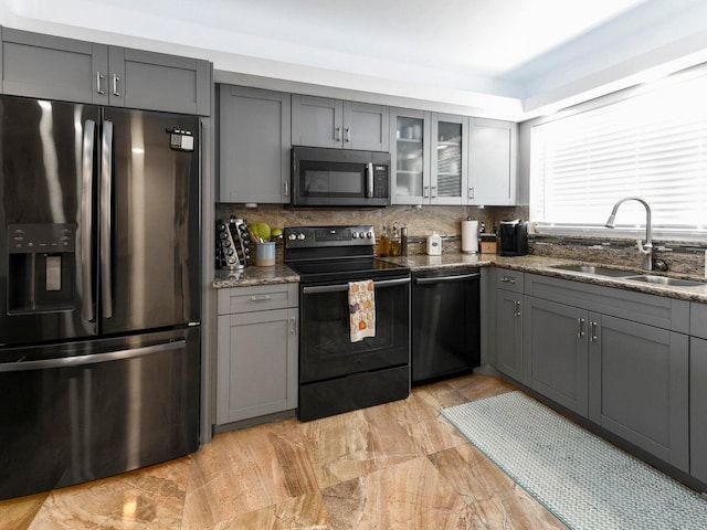 kitchen with sink, tasteful backsplash, black appliances, and gray cabinets