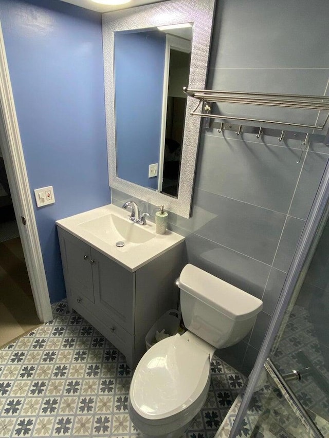 bathroom featuring toilet, tile patterned flooring, and vanity