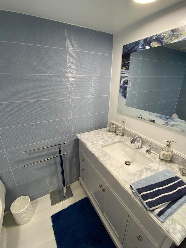 bathroom with tile patterned flooring, tile walls, and vanity