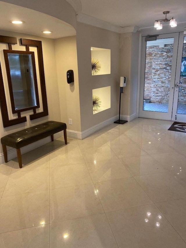 interior space featuring crown molding, light tile patterned floors, and french doors