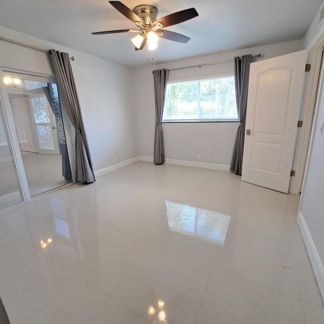 unfurnished room with ceiling fan and light tile patterned floors