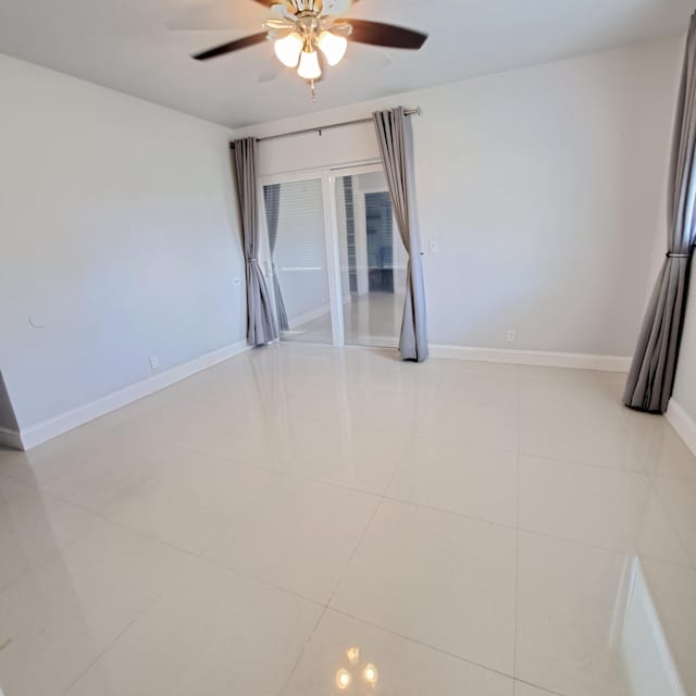 tiled spare room with ceiling fan