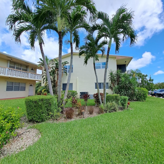 exterior space with a lawn and a balcony