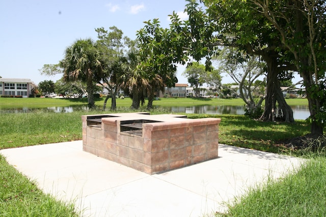 view of home's community featuring a water view and a lawn