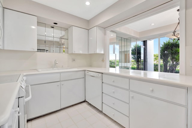 kitchen with white appliances, white cabinetry, and sink